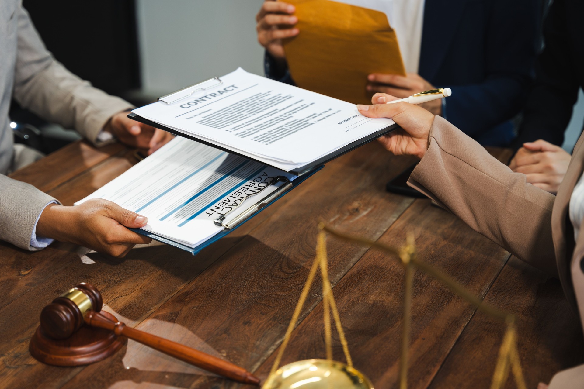 Lawyer signing important legal document on desk at office.